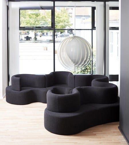 The Moon Pendant Light is one of Verner Panton's earliest lamps, 1964. It consists of ten ring-shaped blades positioned in such a way that they can move. Here it is shown with Verner Panton's Cloverleaf Sofa.
